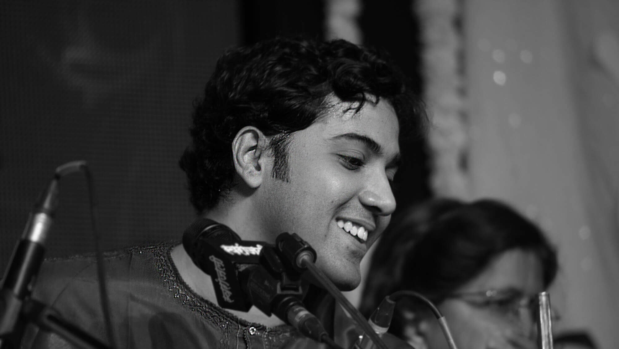 Samrat Pandit black and white portrait of the artist smiling on stage